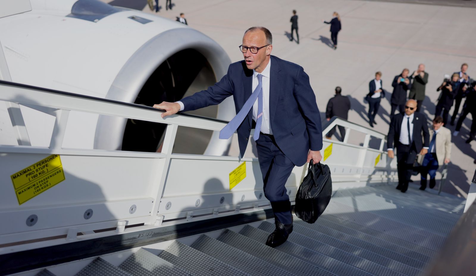 epa12079330 German Chancellor Friedrich Merz boards a plane of German Air Force ’Luftwaffe’ as he departs from the military part of BER airport in Berlin, Germany, 07 May 2025. The German Chancellor visits France and Poland the day after his election.  EPA/HANNIBAL HANSCHKE
