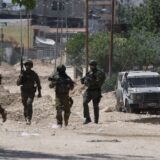 epa12136439 Israeli soliders on guard as Palestinians try to reach their houses to take care of their belongings at Tulkarem refugee camp near the West Bank city of Tulkarem, 26 May 2025.  EPA/ALAA BADARNEH