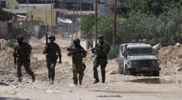 epa12136439 Israeli soliders on guard as Palestinians try to reach their houses to take care of their belongings at Tulkarem refugee camp near the West Bank city of Tulkarem, 26 May 2025.  EPA/ALAA BADARNEH