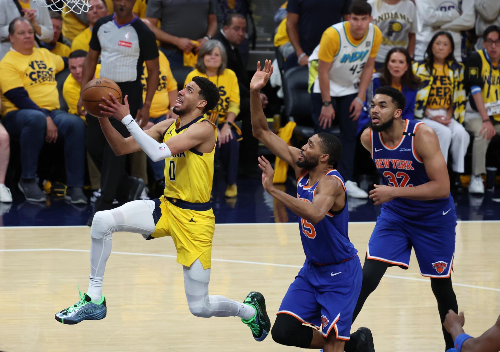 May 27, 2025; Indianapolis, Indiana, USA; Indiana Pacers guard Tyrese Haliburton (0) drives to the hoop past New York Knicks forward Mikal Bridges (25) during the fourth quarter of game four of the eastern conference finals for the 2025 NBA Playoffs at Gainbridge Fieldhouse. Mandatory Credit: Trevor Ruszkowski-Imagn Images/Sipa USA Photo: Imagn Images/SIPA USA