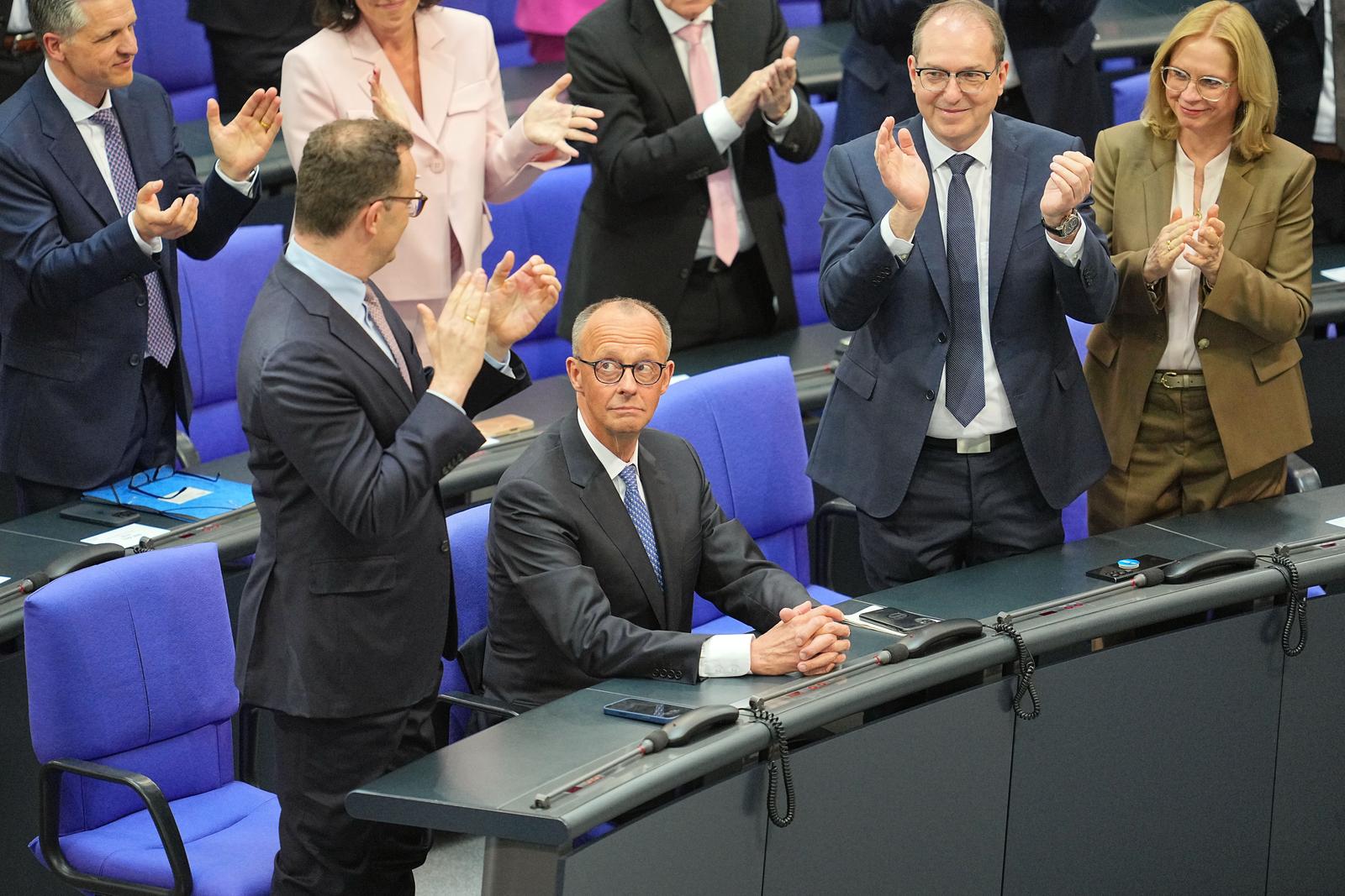 06 May 2025, Berlín: Jens Spahn (left), chairman of the conservative CDU/CSU parliamentary group, and Alexander Dobrindt, interior minister-designate (second from right), applaud Friedrich Merz after his election as Germany's future chancellor. Photo: Michael Kappeler/dpa Photo: Michael Kappeler/DPA