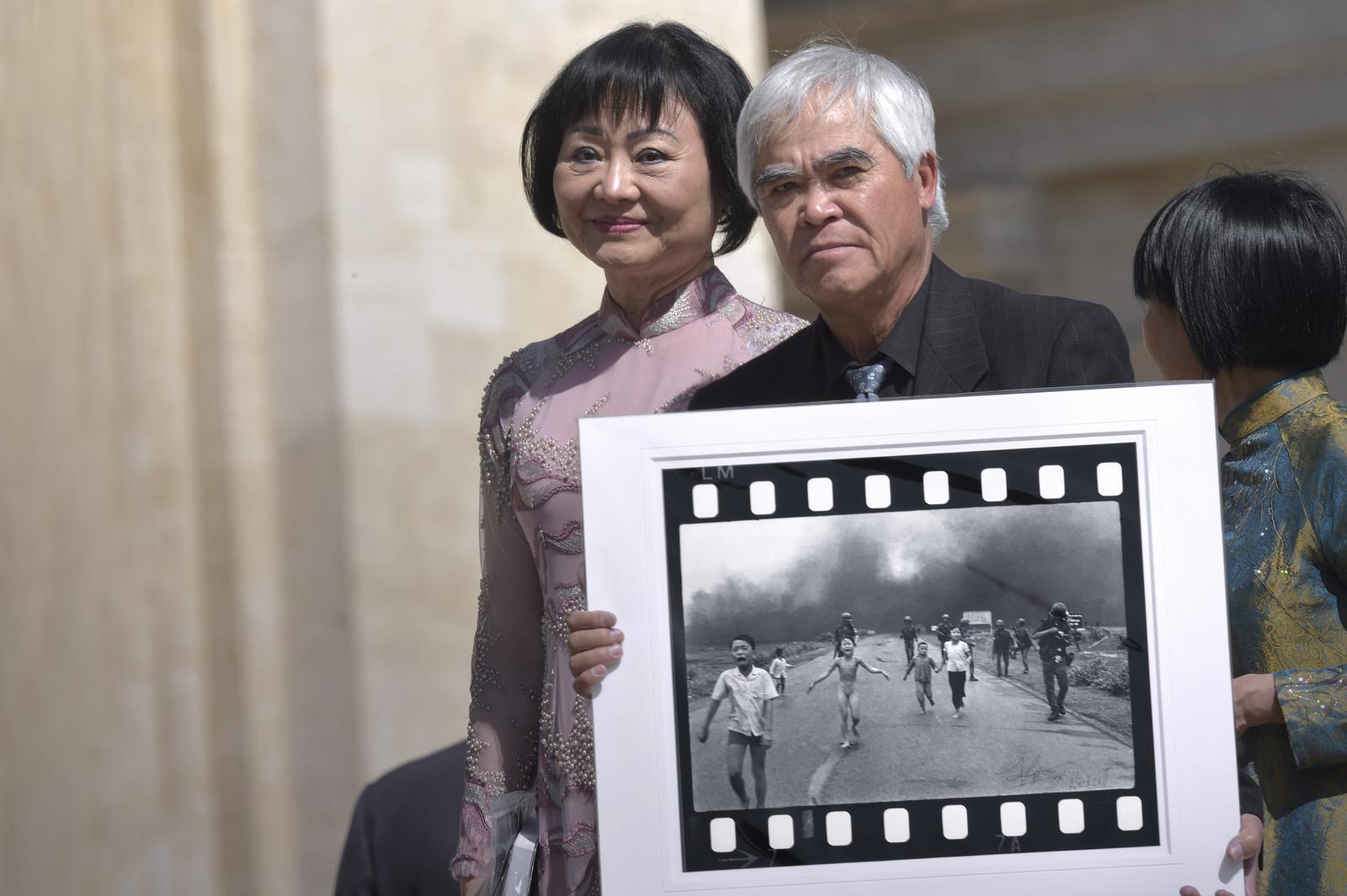 Photographer Nick Ut poses with his 1972 picture The Terror of War, also known as the "Napalm Girl", next to a woman (L) featured in the picture as a child, during the weekly general audience held by Pope Francis at the Vatican, May 11, 2022.
