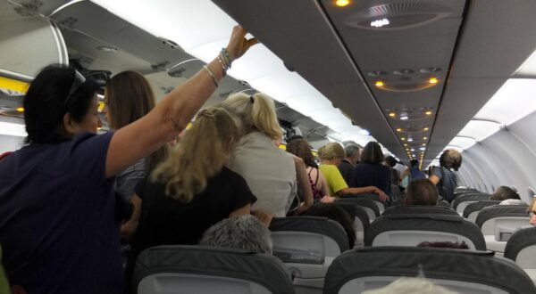 Passagiere Im Gang eines Flugzeuges wartende Passagiere *** Passengers Waiting in the aisle of an airplane Copyright: xRayxvanxZeschaux Photo: IMAGO/IMAGOSTOCK&PEOPLE