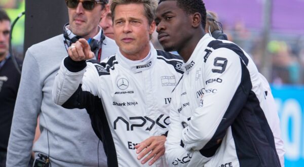 FILE - Actors Brad Pitt, left, and Damson Idris appear on the grid before the British Formula One Grand Prix race at the Silverstone racetrack, Silverstone, England, on July 9, 2023, for the filming of "F1." (AP Photo/Luca Bruno, File) Film-Summer Preview