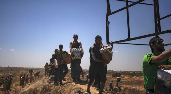 epa12143228 Palestinians carry aid supplies received from the US-backed Gaza Humanitarian Foundation through an area known as the Netzarim Corridor, central Gaza Strip, 29 May 2025. According to the UN half a million people, or one in five people in the Strip are facing starvation while the entire population of the Gaza Strip continues to face a critical risk of famine following 19 months of conflict, mass displacement and severe restrictions on humanitarian aid.  EPA/HAITHAM IMAD