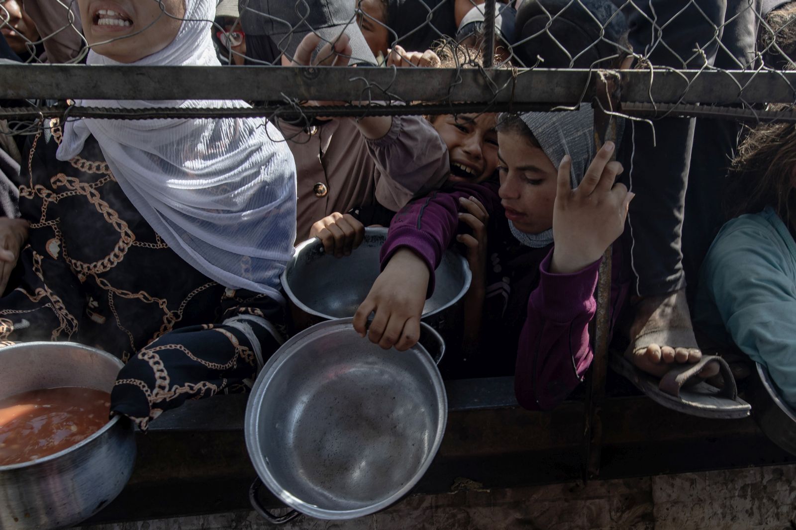 epa12144627 Internally displaced Palestinians gather outside a charity kitchen to receive limited rations amid a shortage of food, in Khan Younis, southern Gaza Strip, 30 May 2025. The United Nations has warned that "the entire population of Gaza is facing the risk of famine" since Israel closed border crossings on 02 March 2025, preventing the entry of essential supplies. The Gaza Government Media Office reported on 24 May that at least 58 people died due to malnutrition, and nearly 250 others due to a lack of food and medicine.  EPA/HAITHAM IMAD