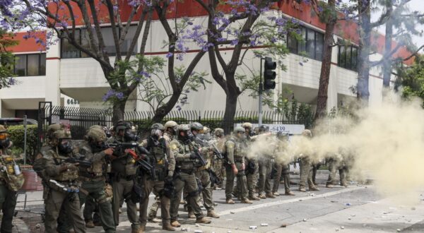 epa12163076 Federal agents fire flash-bang smoke grenades at protestors near a Home Depot after a raid was conducted by Immigration and Customs Enforcement (ICE) in Paramount, California, USA, 07 June 2025. This comes the day after federal immigration authorities arrested more than 40 people across Los Angeles, as protesters gathered outside a federal detention center.  EPA/ALLISON DINNER