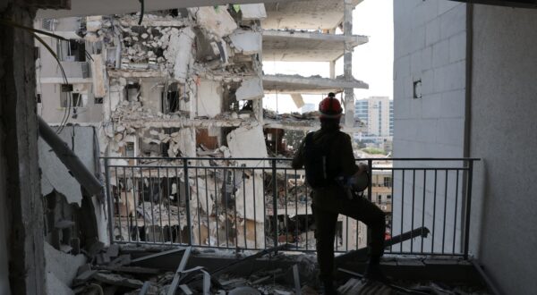 epa12177058 Members of Israel's Home Front Command search for missing people at the site of a partially collapsed residential building after Iranian ballistic missiles hit Bat Yam, central Israel, 15 June 2025. Iran launched a barrage of ballistic missiles at Israel overnight in retaliation for Israeli airstrikes on Iranian targets. Magen David Adom (MDA), Israel's national emergency services, reported at least six killed and dozens injured, including two in critical condition.  EPA/ABIR SULTAN