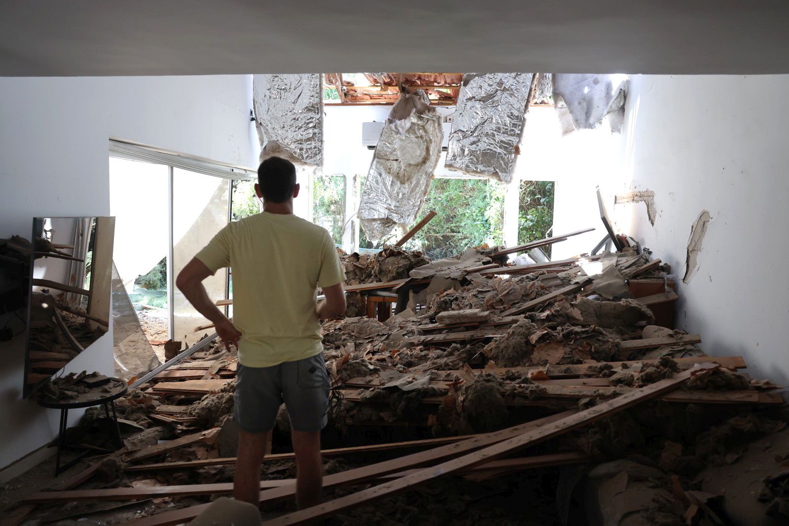 epa12190555 An Israeli resident inspects his damaged living room following an Iranian missile strike on a residential building complex in Tel Aviv, Israel, 22 June 2025. Israel and Iran have been exchanging fire since Israel launched strikes across Iran on 13 June 2025 as part of Operation 'Rising Lion.'  EPA/ABIR SULTAN