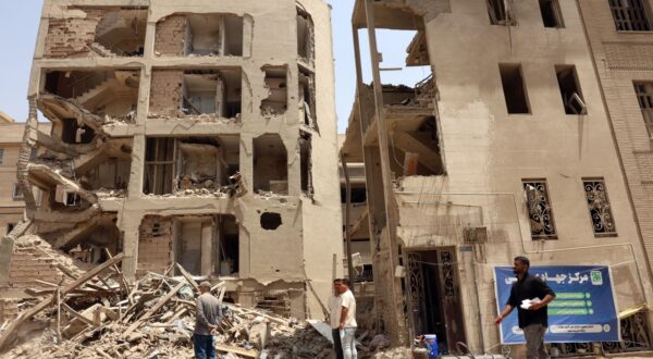 epaselect epa12198613 People walk past damaged houses following a recent Israeli airstrike in the capital city of Tehran, Iran, 26 June 2025. Israel and Iran have been exchanged fire since Israel launched strikes across Iran on 13 June 2025 as part of Operation 'Rising Lion.'  EPA/ABEDIN TAHERKENAREH
