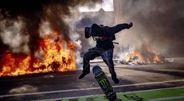 A protester leaps on a skateboard while two Waymo self-driving cars burn in the background and people continue their anti-ICE demonstrations in Los Angeles, California, on Sunday June 8, 2025. Protests erupted earlier on Friday when ICE Federal agents arrested immigrants in LA's fashion district, in a Home Depot parking lot, and several other locations. Photo by Sahab Zaribaf/Middle East Images/ABACAPRESS.COM Photo: Middle East Images/ABACA/ABACA