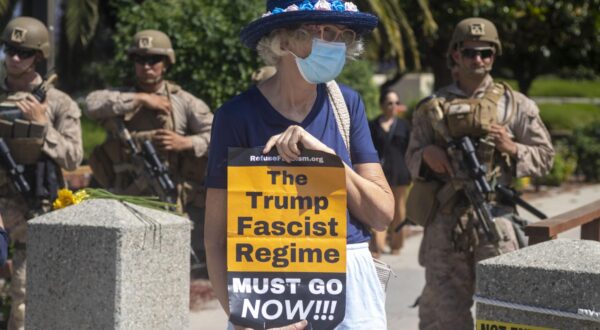 A woman holds an anti Trump placard as U.S Marines stand guard outside of a federal building. A federal appeals court ruled on June 12 that the Trump administration can maintain control of the California National Guard overturning a lower court ruling that U.S. President Donald Trump's deployment of troops without Governor Gavin Newsom's consent is unlawful. (Photo by Ringo Chiu / SOPA Images/Sipa USA) Photo: SOPA Images/SIPA USA