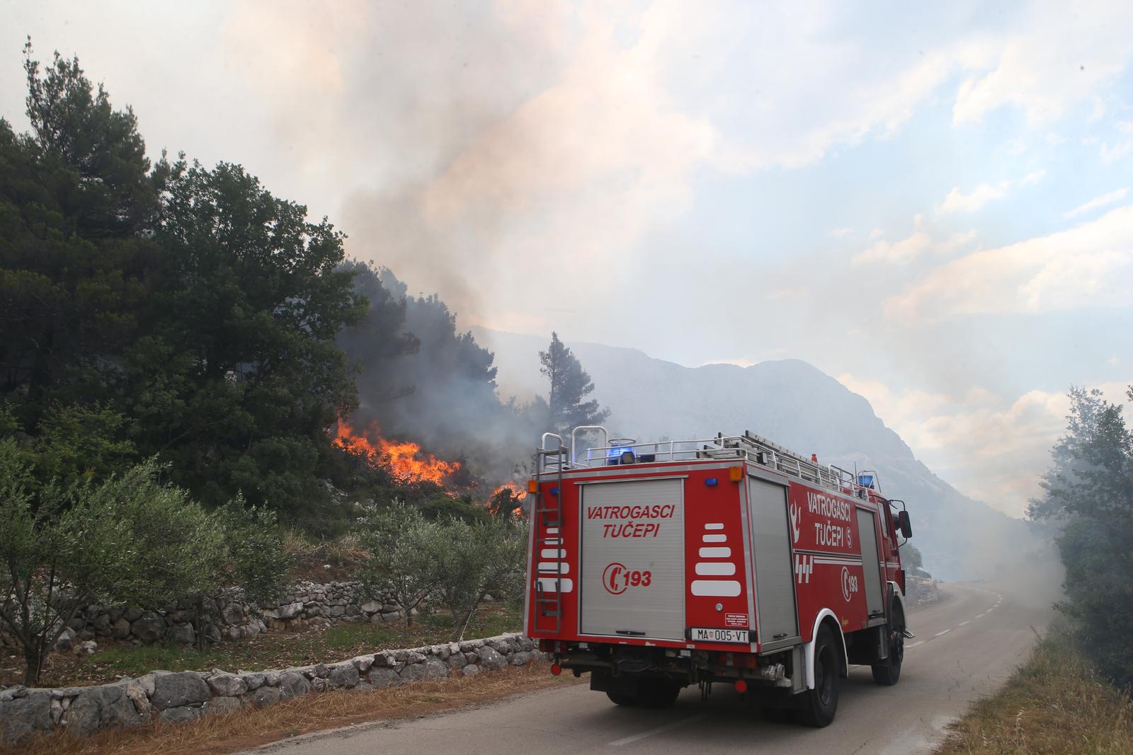 18.06.2017., Podgora - Veliki sumski pozar na padinama Biokova izmedju Gornjih Tucepa i Podgore. Od jutra je zatvoren promet na cestama koje vode u ta mjesta makarskog primorja, a na terenu vatru gase vatrogasci iz Splitsko-dalmatinske zupanije i DIP Sibenik kojima bura stvara problema. Kuce trenutno nisu ugrozene, a vatra se prosirila na Park prirode Biokovo.rPhoto: Ivo Cagalj/PIXSELL