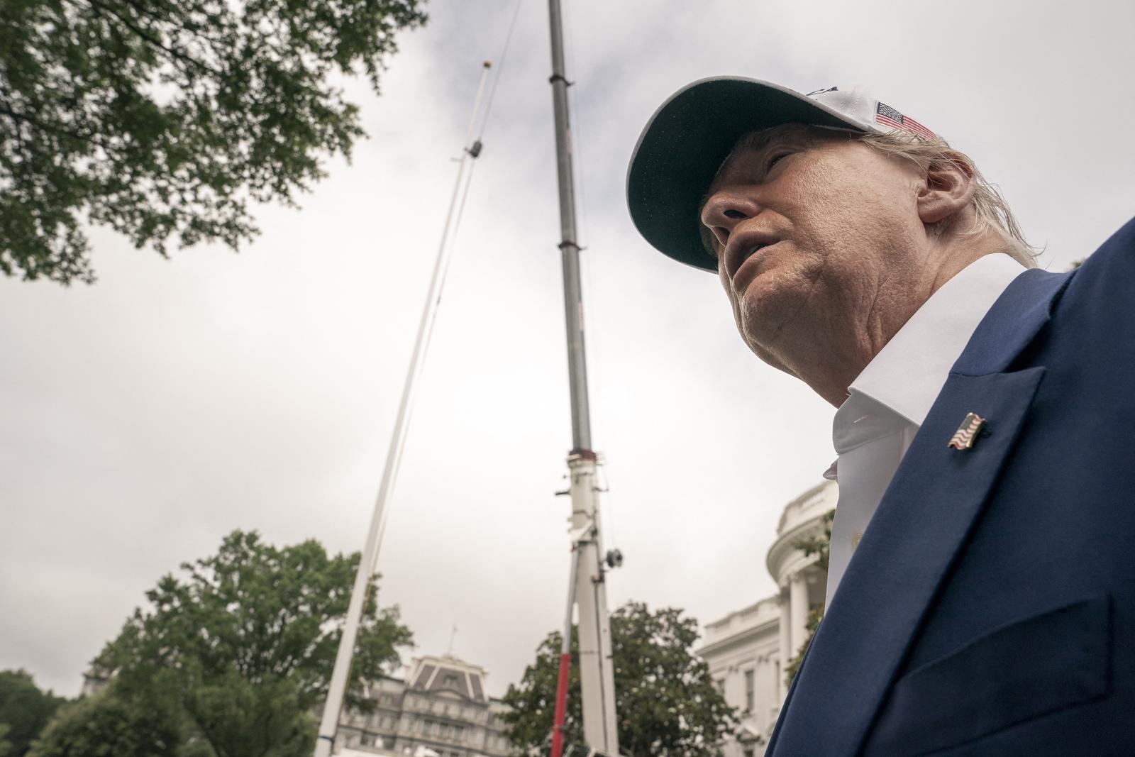 U.S. President Donald Trump looks back at workers as they install a new flag pole on the South Lawn at the White House in Washington, DC on Wednesday, June 18, 2025. Photo by Ken Cedeno/Pool/ABACAPRESS.COM Photo: Pool/ABACA/ABACA