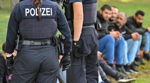 11 October 2023, Brandenburg, Forst: Illegal migrants are guarded by officers of the Federal Police during an apprehension near the German-Polish border in Forst (Lausitz). During several operations in Forst, Brandenburg, and the surrounding area, the Federal Police had apprehended at least 64 migrants who had entered the country without permission on Oct. 11, 2023. According to their own information, they were brought to Germany by smugglers via the so-called Balkan route from Turkey via Greece, Bulgaria, Hungary, Slovakia and Poland and dropped off shortly after the border. For several weeks now, the German Federal Police have been stepping up their search for criminals who bring refugees and migrants to Germany without permission by carrying out mobile checks at the German-Polish border. Photo: Patrick Pleul/dpa Photo: Patrick Pleul/DPA