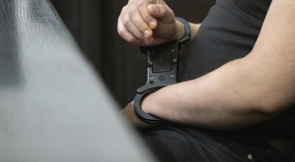 22 May 2025, Baden-Württemberg, Stuttgart: A defendant in custody in the trial over bomb threats in the southwest is sitting in a courtroom at Stuttgart Regional Court. The two accused young men are alleged to have sent bomb threats to several facilities and institutions in October and November 2023, including the University of Stuttgart, the Israelite community in Ulm, the Heilbronn district office, the KIT in Karlsruhe and the police academy in Villingen-Schwenningen. Photo: Marijan Murat/dpa Photo: Marijan Murat/DPA