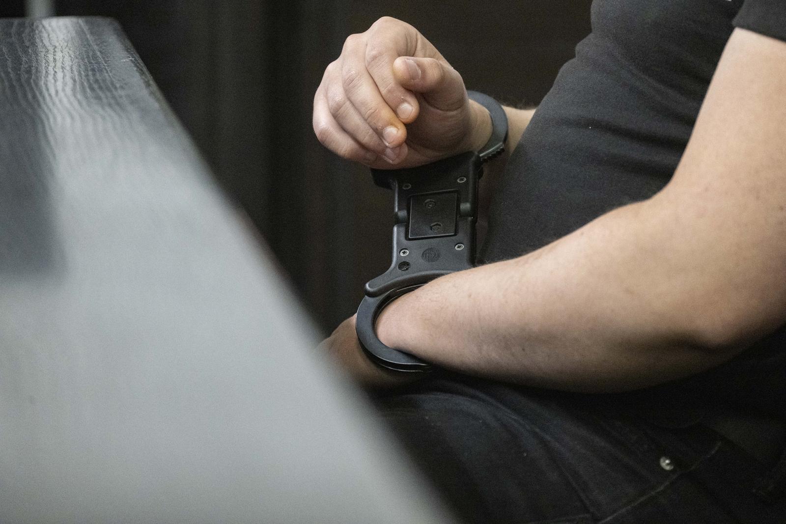 22 May 2025, Baden-Württemberg, Stuttgart: A defendant in custody in the trial over bomb threats in the southwest is sitting in a courtroom at Stuttgart Regional Court. The two accused young men are alleged to have sent bomb threats to several facilities and institutions in October and November 2023, including the University of Stuttgart, the Israelite community in Ulm, the Heilbronn district office, the KIT in Karlsruhe and the police academy in Villingen-Schwenningen. Photo: Marijan Murat/dpa Photo: Marijan Murat/DPA