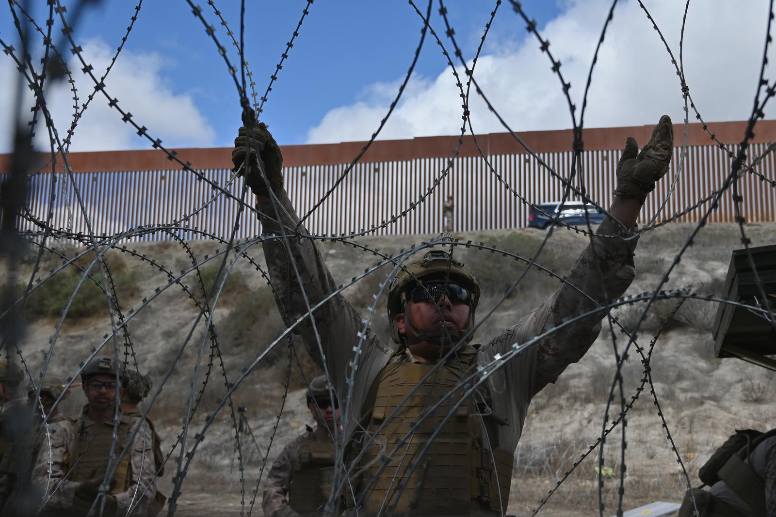 A member of the US Marine Corps installing concertina wire along the US-Mexico border wall in San Diego, California, seen from Tijuana, Mexico in between the San Diego-Tijuana border fences of Colonia Libertad on Thursday, February 06, 2025. The Defense Department deployed 1,600 active-duty troops to the border during US President Donald Trumps first week in office. (Photo by Carlos Moreno/Sipa USA)  Photo: Carlos Moreno/SIPA USA