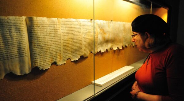 QUMRAN, ISR - DEC 14:Woman looks at the Dead Sea Scrolls on display at the caves of Qumran on December 14 2008.The Dead Sea Scrolls were discovered in eleven caves in Qumran near the Dead Sea between the years 1947 and 1956. Photo via Newscom Photo: RAFAEL BEN ARI/CHAMELEONS EYE/NEWSCOM