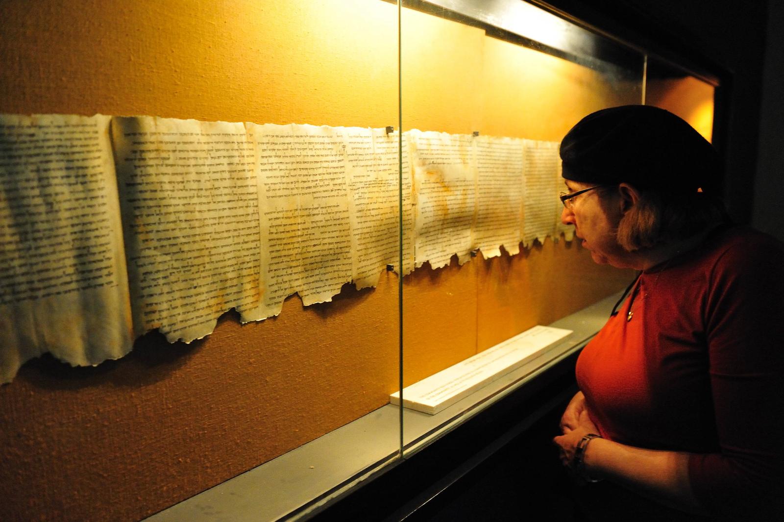 QUMRAN, ISR - DEC 14:Woman looks at the Dead Sea Scrolls on display at the caves of Qumran on December 14 2008.The Dead Sea Scrolls were discovered in eleven caves in Qumran near the Dead Sea between the years 1947 and 1956. Photo via Newscom Photo: RAFAEL BEN ARI/CHAMELEONS EYE/NEWSCOM