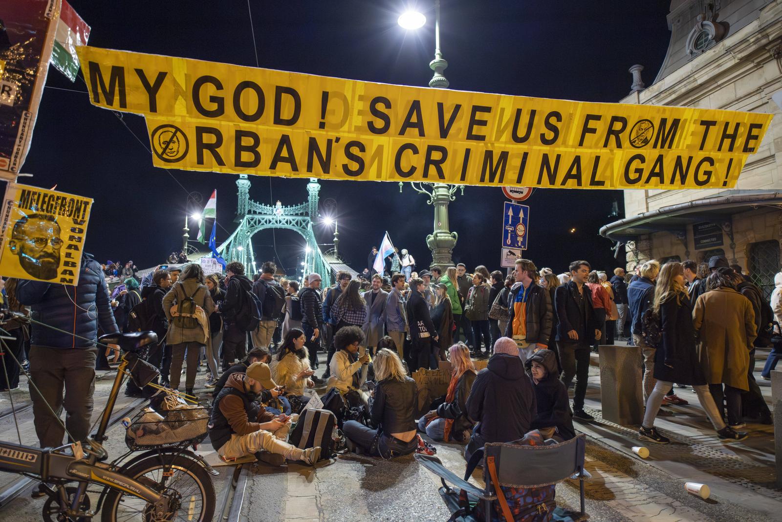 anti-government demonstation / Pride, Budapest, Hungary UNGARN, 04.2025, Budapest V. Bezirk. Demonstrationsserie mit Brueckensperrungen hier: Szabadsag Bruecke nach dem Vorstoss der Fidesz-Regierung, den jaehrlichen LGBTQ Pride-Aufzug zu verbieten. Lieber Gott, rette uns vor Orbans krimineller Bande Links: Jozsef Szajer, beruehmt-schwuler Fidesz-Politiker. Series of demonstrations and Danube bridge blockades here: Liberty bridge following the announcement of the Fidesz government to ban the annual LGBTQ pride parade. To the left Jozsef Szajer, famously gay Fidesz politician. Â *** anti government demonstation Pride, Budapest, Hungary HUNGARY, 04 2025, Budapest V district Series of demonstrations and Danube bridge blo Copyright: MARTIN_FEJER_ESTOST_PHOTOGRAPHY Fejer25040141 Photo: IMAGO/MARTIN_FEJER_EST+OST_PHOTOGRAPHY/IMAGOSTOCK&PEOPLE