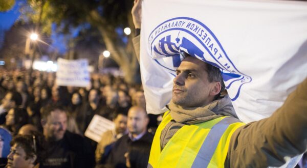 A man holds a banner with the logo of the trade union of bank employees of Cyprus (ETYK) in Nikosia, Cyprus, 23 March 2013. Discussions continue on Cyprus for a way out of the country's crisis. Photo: