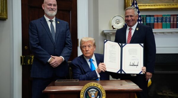 epa12273463 US President Donald Trump (C), flanked by US Representatives Derrick Van Orden (Republican from Wisconsin) and Mike Bost (Republican from Illinois), shows the signed Congressional Bill in the Roosevelt Room at the White House in Washington, SC, USA, 30 July 2025.  EPA/YURI GRIPAS / POOL