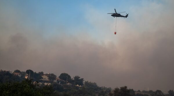 epa12207116 A helicopter carries water to put out the fire during the wildfires in the Seferihisar district of Izmir, Turkey, 30 June 2025. Turkish Forestry Minister Ibrahim Yumakli said the blaze in the Kuyucak and Doganbey areas of Izmir was fanned overnight by winds reaching 40–50 km/h (25–30 mph), leading to the evacuation of four villages and two neighbourhoods.  EPA/MURAT KOCABAS