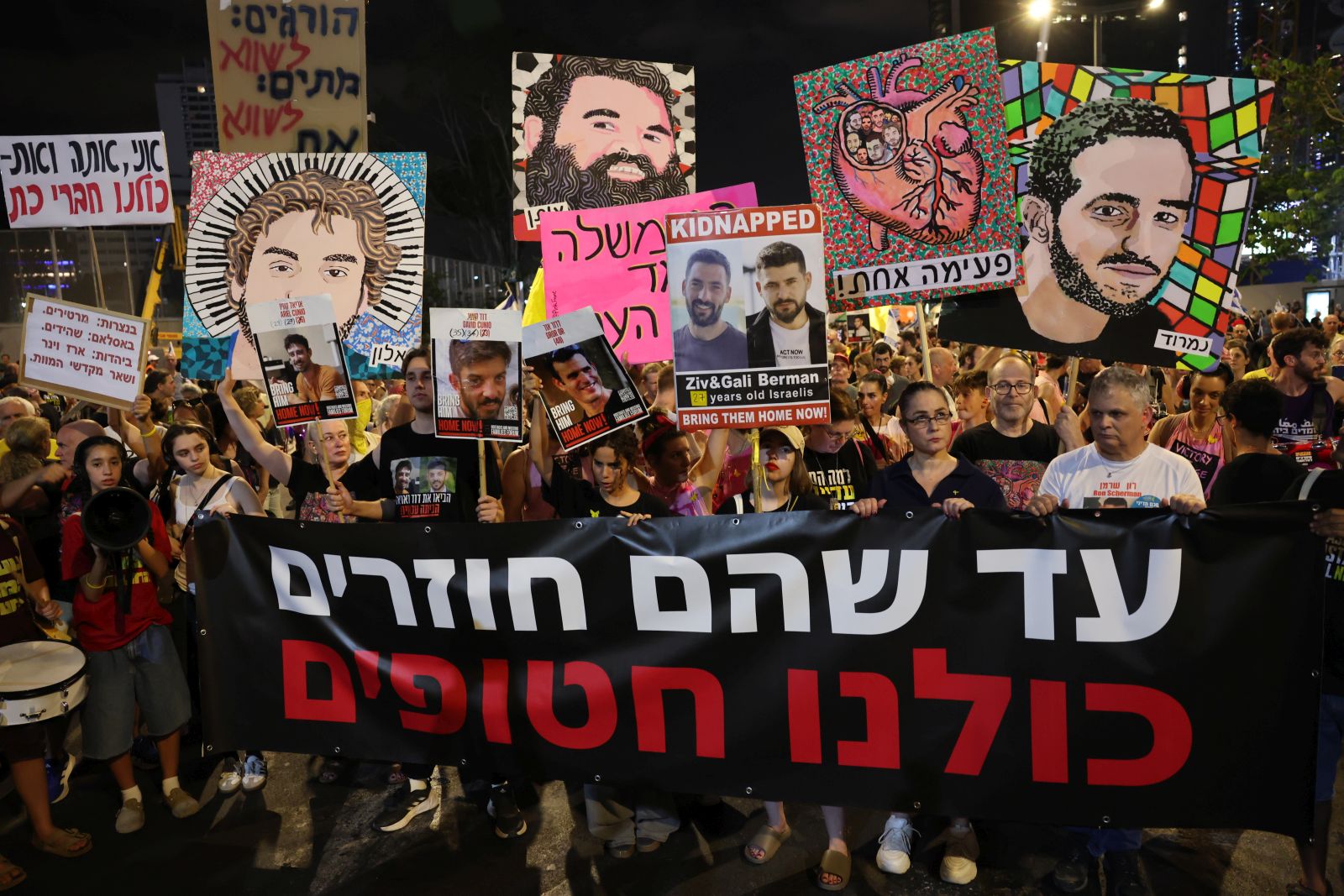 epa12234425 Families of Israeli hostages held by Hamas in Gaza hold a banner with 'until they will return we are all hostages' written in Hebrew during protest outside the Kirya military headquarters in Tel Aviv, Israel, 12 July 2025. According to the Israeli army (IDF) spokesperson, around 50 Israeli hostages remain in captivity in the Gaza Strip, including the bodies of at least 30 confirmed dead.  EPA/ABIR SULTAN