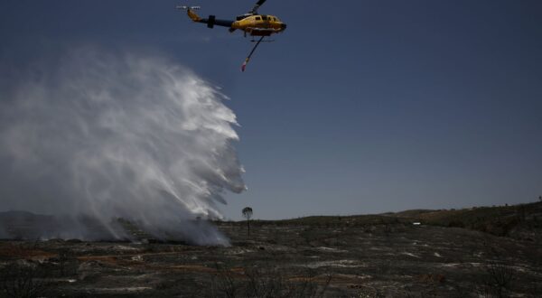 epaselect epa12265552 A firefighting helicopter operates in a burned area after a wildfire in the area of Kryoneri, in the suburbs of Athens, Greece, 27 July 2025. The fire, which started on July 26 in the residential area of Kryoneri, Attica, has burned homes, forest, and land. Currently, there is no active fire front; however, firefighters are working to control hotspots within the affected areas.  EPA/YANNIS KOLESIDIS