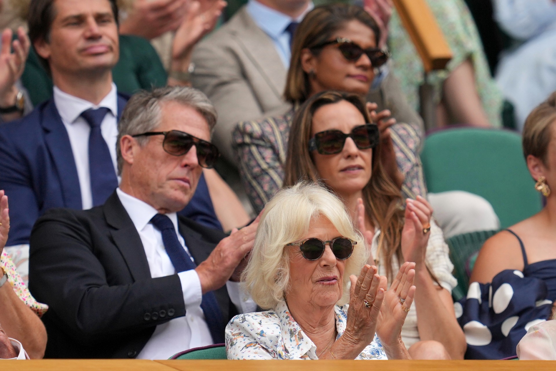 Britain's Queen Camilla sits in front of actor Hugh Grant and his wife Anna in the Royal Box on Centre Court on day ten at the Wimbledon Tennis Championships in London, Wednesday, July 9, 2025. (AP Photo/Kin Cheung) Britain Wimbledon Tennis