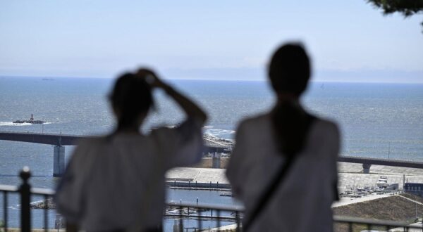 People watch the sea from higher ground in Ishinomaki in Miyagi Prefecture, northeastern Japan, on July 30, 2025, after the Japan Meteorological Agency issued a tsunami warning for the country's Pacific coast following a powerful earthquake off Russia's Kamchatka Peninsula. (Kyodo) ==Kyodo  Photo via Newscom