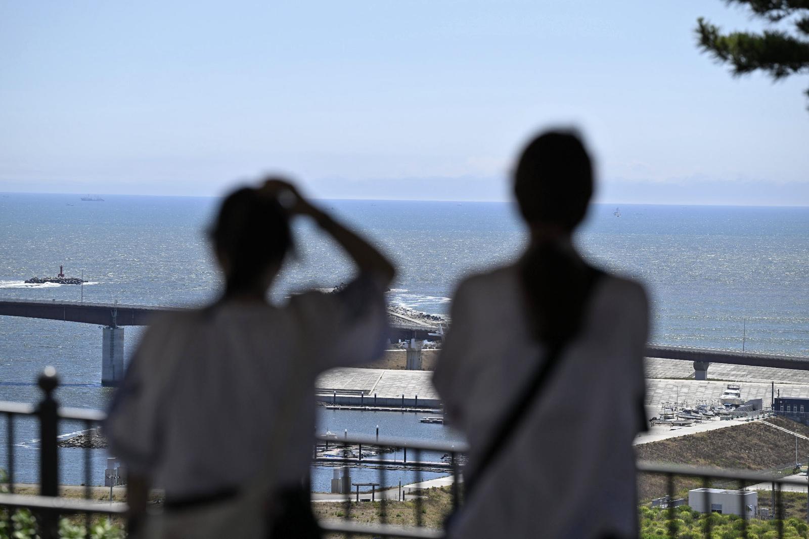 People watch the sea from higher ground in Ishinomaki in Miyagi Prefecture, northeastern Japan, on July 30, 2025, after the Japan Meteorological Agency issued a tsunami warning for the country's Pacific coast following a powerful earthquake off Russia's Kamchatka Peninsula. (Kyodo) ==Kyodo  Photo via Newscom