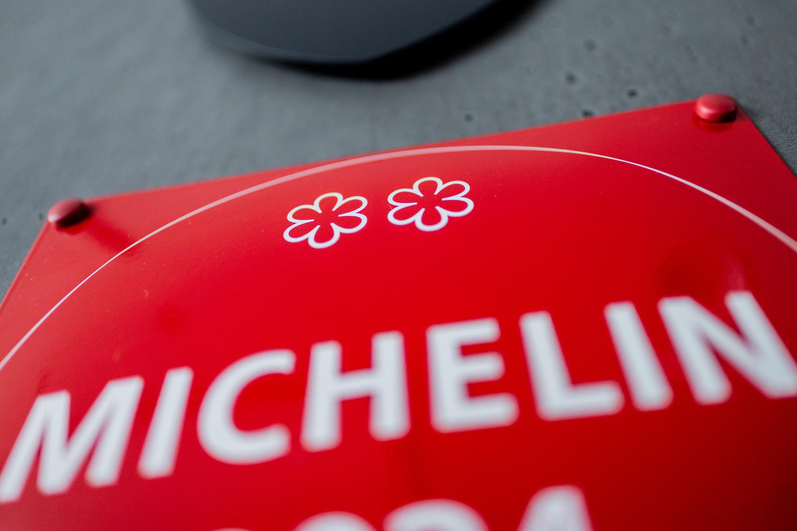 PRODUCTION - 26 June 2025, North Rhine-Westphalia, Cologne: 2 Michelin stars can be seen on a Michelin Guide plaque in front of the kitchen of Michelin-starred chef Daniel Gottschlich's restaurant "Ox & Klee". Photo: Rolf Vennenbernd/dpa Photo: Rolf Vennenbernd/DPA