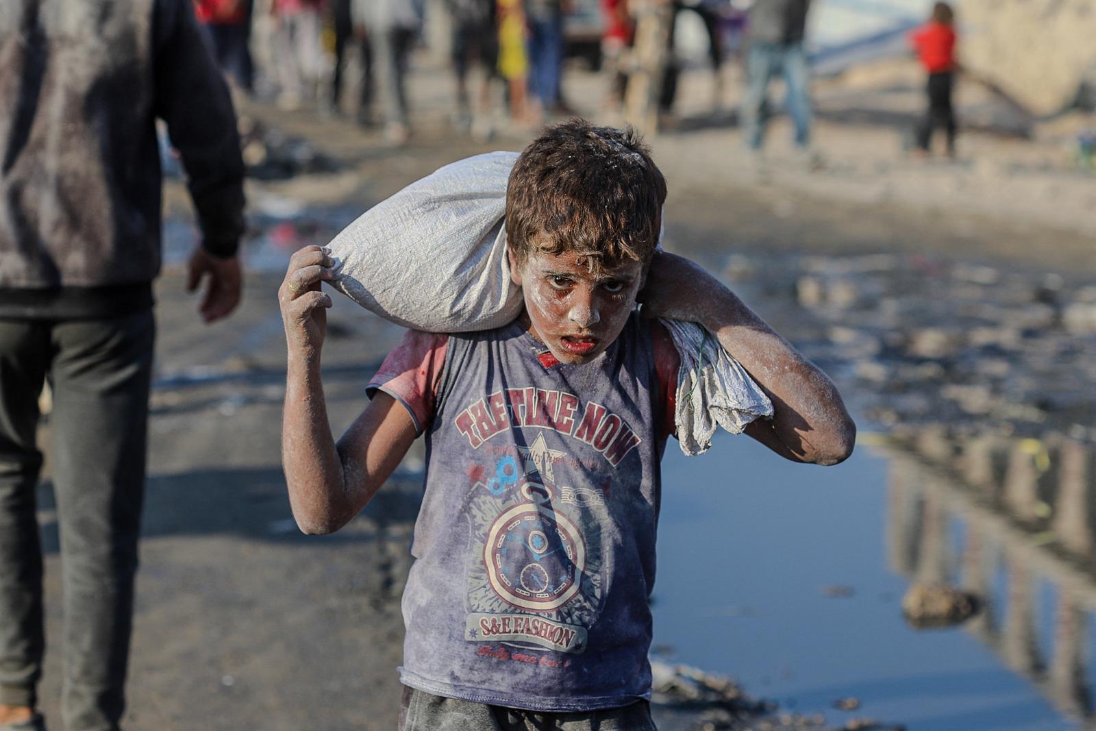 Palestinians carry humanitarian aid received through the Zikim crossing as they return to their families near the Al-Sudaniya area in northern Gaza, Palestine on July 26 2025, reflecting the ongoing humanitarian crisis in the Strip. Photo by Ramez Habboub/ABACAPRESS.COM Photo: Habboub Ramez/ABACA/ABACA