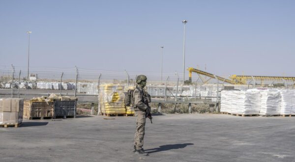 24 July 2025, Palestinian Territories, Kerem Shalom: An Israeli soldier stands beside humanitarian aid packages awaiting pickup on the Palestinian side of the Kerem Shalom crossing in the Gaza Strip during a media tour organized by the Israeli army. Photo: Ilia Yefimovich/dpa Photo: ILIA YEFIMOVICH/DPA
