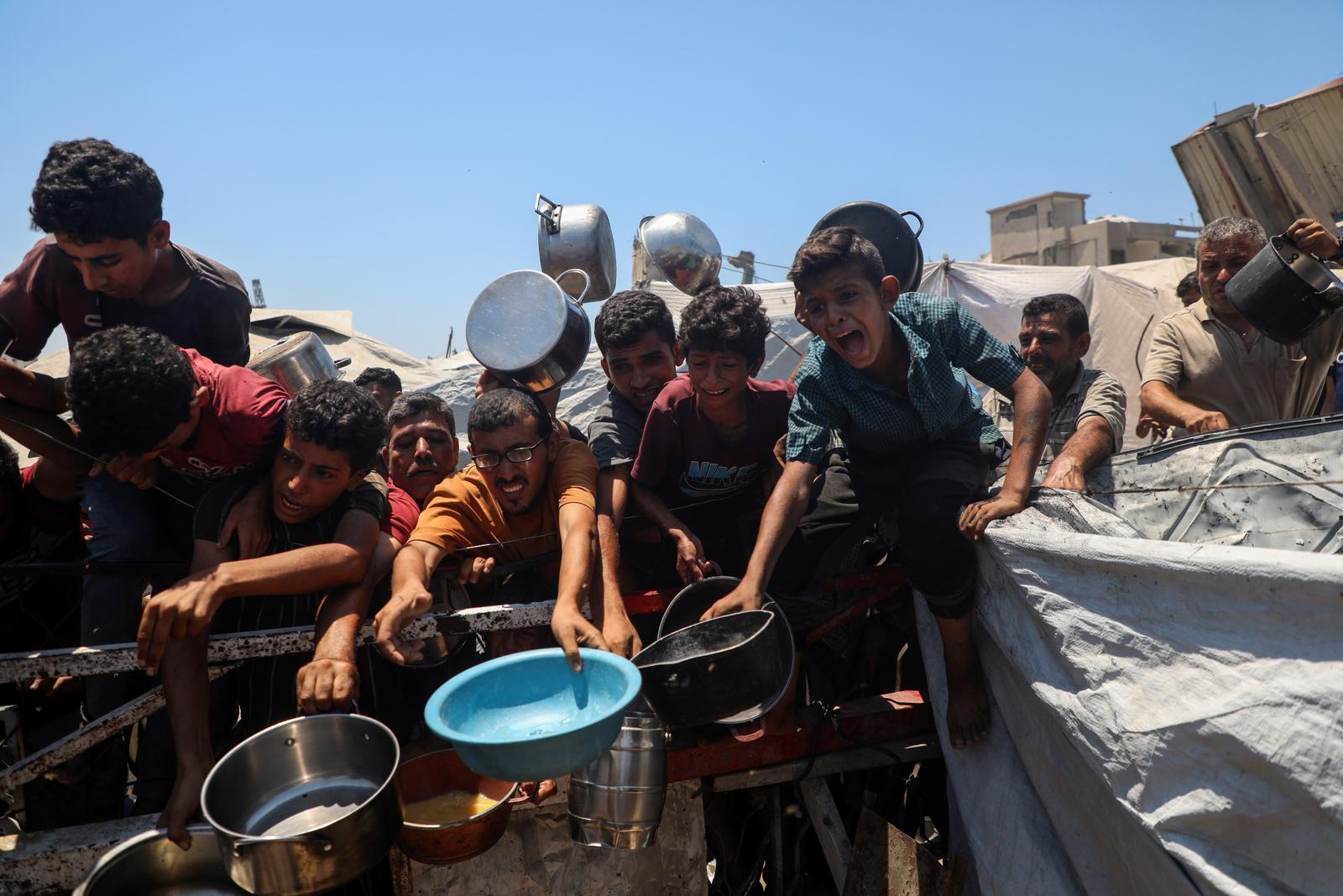 (250724) -- GAZA, July 24, 2025 (Xinhua) -- Palestinians wait to receive free food from a charity kitchen in Gaza City, on July 24, 2025. The Palestinians are facing "the biggest humanitarian catastrophe" of their time amid the ongoing conflict in Gaza and the West Bank, due to the failure of global efforts to deter Israeli actions, Palestinian President Mahmoud Abbas said Thursday. (Photo by Rizek Abdeljawad/Xinhua) Photo: Rizek Abdeljawad/XINHUA