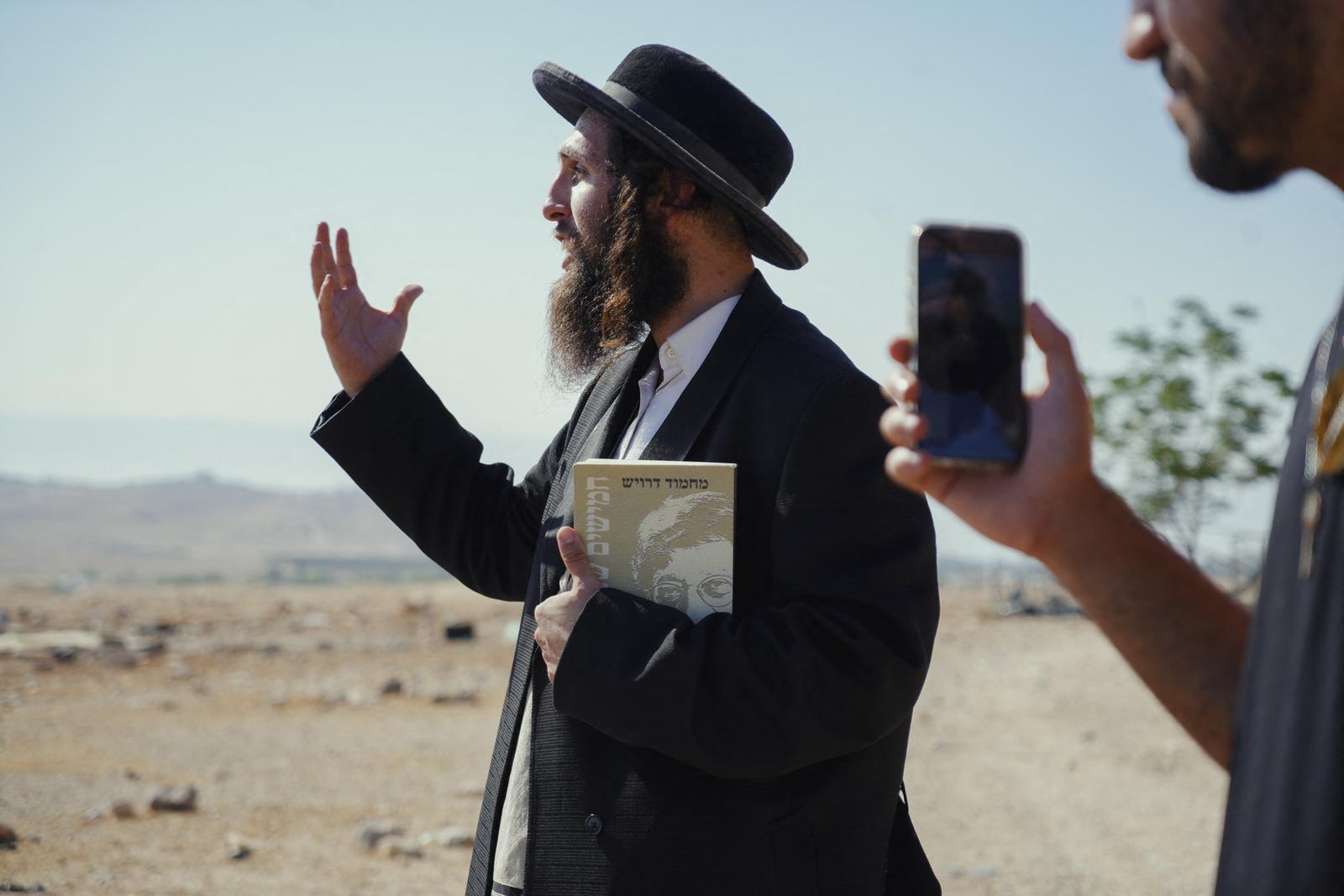 Yehonathan, an Israeli activist, stands near the Bedouin communities in the villages of Al-Muarrajat and Ras al-Ain in the Jordan Valley, occupied West Bank, on June 26, 2025. He came to provide a protective presence for Palestinian Bedouins who report regular harassment by settlers; in his hand, he holds a book by Palestinian poet Mahmoud Darwish. Photo by Khadija Toufik/Middle East Images/ABACAPRESS.COM Photo: Middle East Images/ABACA/ABACA