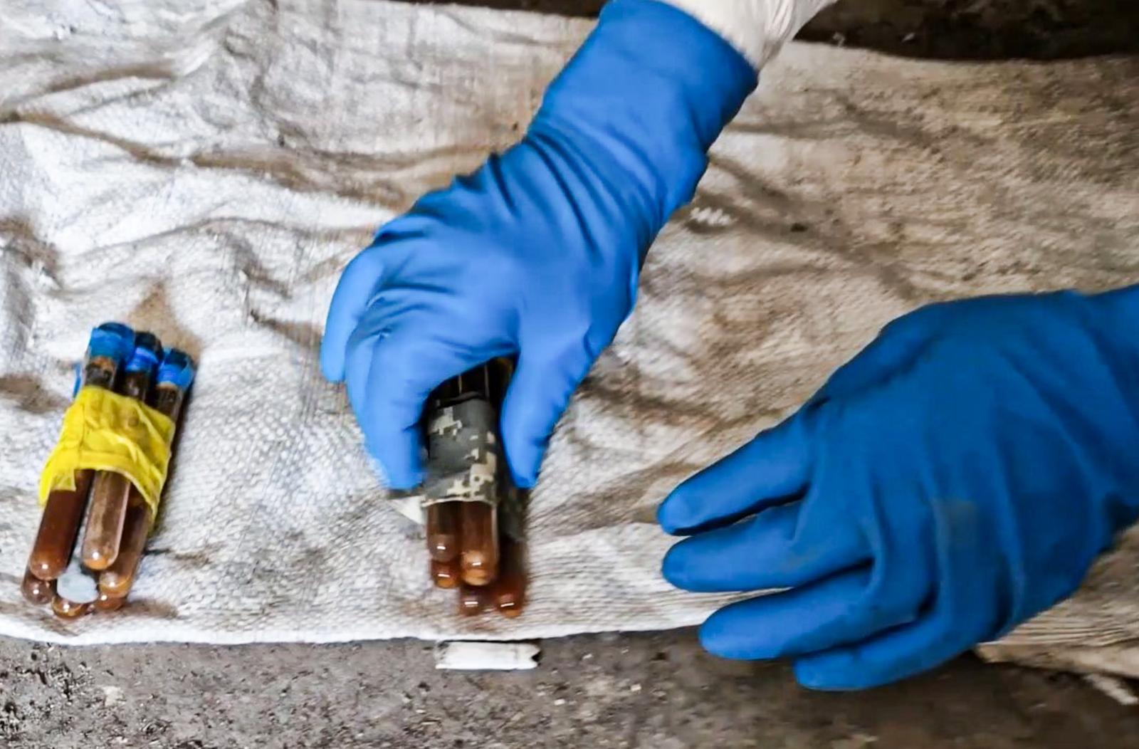 RUSSIA, DONETSK PEOPLE'S REPUBLIC - JULY 1, 2025: A person wearing a protective suit discovers a cache of improvised explosive devices containing chloropicrin, a chemical warfare agent prohibited under the UN Chemical Weapons Convention. Video screen grab. Best quality available. Russian Federal Security Service Photo: Tass/SIPA USA