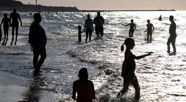 (220814) -- USTKA, Aug. 14, 2022 (Xinhua) -- People play on the beach near Baltic city Ustka, Poland, on Aug. 13, 2022. Tourists went for the Baltic seaside to enjoy weekend amid hot summer time. (Photo by Alexey Vitvitsky/Xinhua). Photo: Alexey Vitvitsky/XINHUA