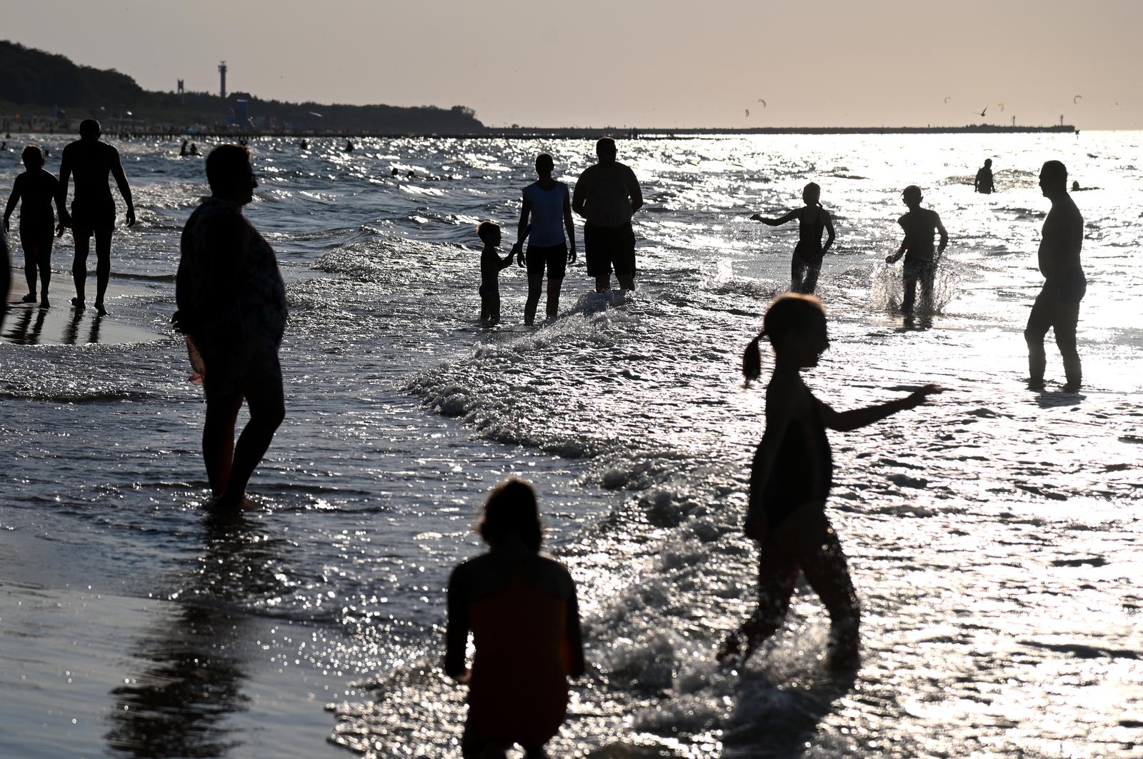 (220814) -- USTKA, Aug. 14, 2022 (Xinhua) -- People play on the beach near Baltic city Ustka, Poland, on Aug. 13, 2022. Tourists went for the Baltic seaside to enjoy weekend amid hot summer time. (Photo by Alexey Vitvitsky/Xinhua). Photo: Alexey Vitvitsky/XINHUA