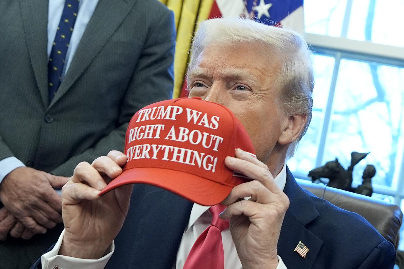 United States President Donald Trump holds a hat reading "Trump was right about everything" after signing Executive Orders in the Oval Office of the White House in Washington on January 23, 2025. 
Credit: Yuri Gripas / Pool via CNP/AdMedia Photo: CNP/AdMedia/NEWSCOM