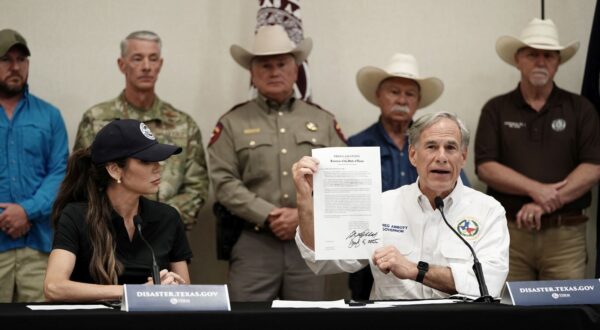 epa12219111 Governor of Texas Greg Abbott (R) signs a disaster declaration with US Secretary of Homeland Security Kristi Noem (L) by his side, in Kerrville, Texas, USA, 05 July 2025. Search and Rescue teams continued working around the clock following flash flooding on the Guadalupe River in Kerr County. Early 04 July, floodwaters swept through a summer camp and nearby homes, killing at least two dozen people, with dozens of campers still unaccounted for.  EPA/DUSTIN SAFRANEK