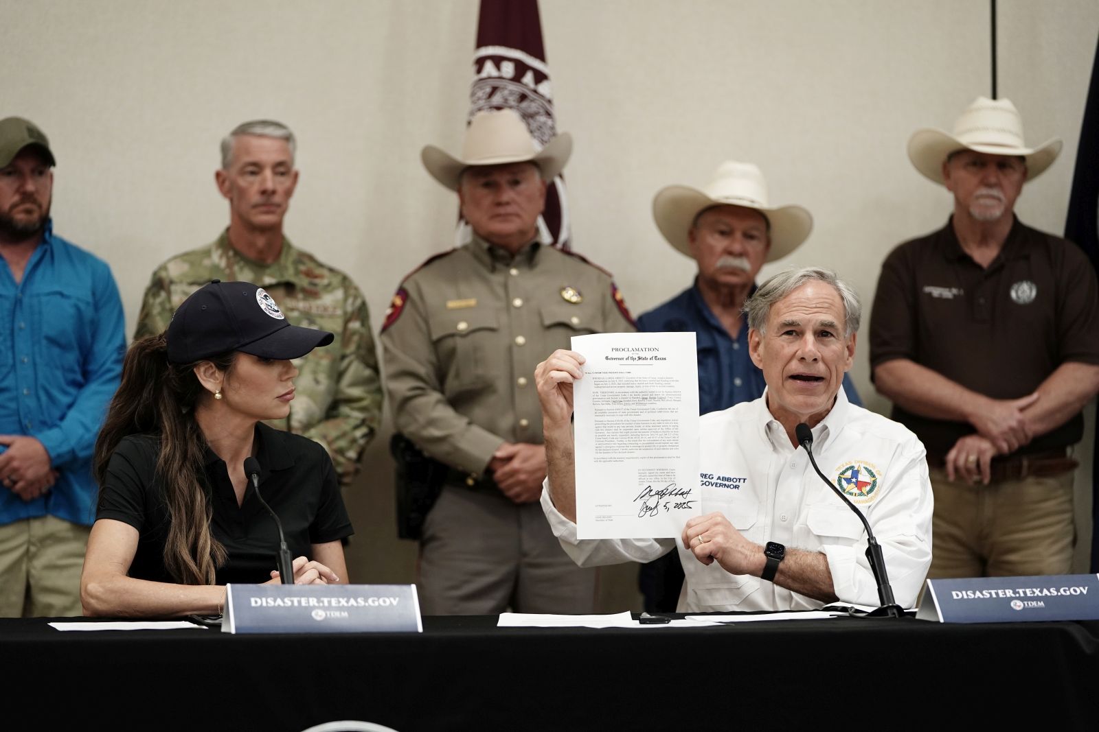 epa12219111 Governor of Texas Greg Abbott (R) signs a disaster declaration with US Secretary of Homeland Security Kristi Noem (L) by his side, in Kerrville, Texas, USA, 05 July 2025. Search and Rescue teams continued working around the clock following flash flooding on the Guadalupe River in Kerr County. Early 04 July, floodwaters swept through a summer camp and nearby homes, killing at least two dozen people, with dozens of campers still unaccounted for.  EPA/DUSTIN SAFRANEK