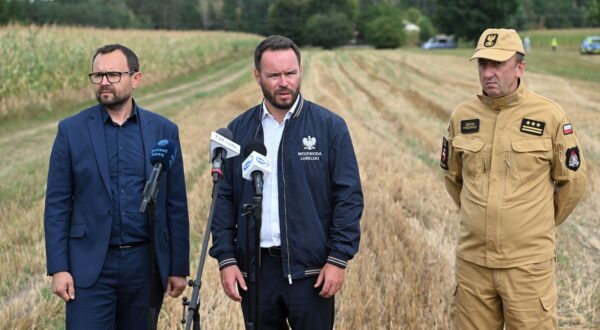 epa12311950 Lublin Province Governor Krzysztof Komorski (L), Lublin District Prosecutor Grzegorz Trusiewicz (C), and Lublin Provincial Fire Service Commander Senior Brigadier Zenon Pisiewicz (R)  attend a press conference next to a cornfield where an unidentified object fell in Osiny, eastern Poland, 20 August 2025. The object fell during the night from 19 to 20 August and exploded. Police found burnt metal and plastic debris at the site. As a result of the explosion, windows were broken in several houses nearby. No one was injured in the incident. According to the military, there was no violation of Polish airspace during the night.  EPA/Wojtek Jargilo POLAND OUT