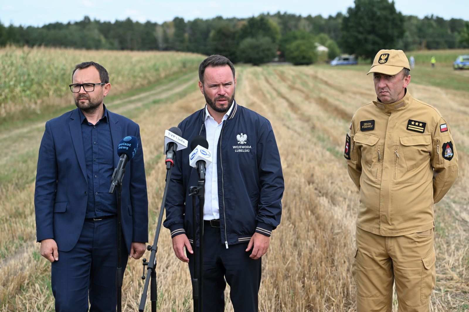 epa12311950 Lublin Province Governor Krzysztof Komorski (L), Lublin District Prosecutor Grzegorz Trusiewicz (C), and Lublin Provincial Fire Service Commander Senior Brigadier Zenon Pisiewicz (R)  attend a press conference next to a cornfield where an unidentified object fell in Osiny, eastern Poland, 20 August 2025. The object fell during the night from 19 to 20 August and exploded. Police found burnt metal and plastic debris at the site. As a result of the explosion, windows were broken in several houses nearby. No one was injured in the incident. According to the military, there was no violation of Polish airspace during the night.  EPA/Wojtek Jargilo POLAND OUT