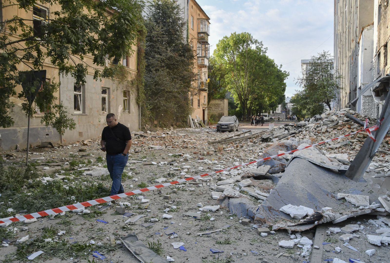 epa12313931 People walk at the site of a Russian strike on a residential area after a massive overnight attack  in Lviv, Ukarine, 21 August 2025, amid the ongoing invasion. One person was killed and at least three others were injured in the western Ukrainian city after Russia launched a large-scale assault involving at least 40 missiles of different types and 574 drones across the country, according to the State Emergency Service.  EPA/MYKOLA TYS