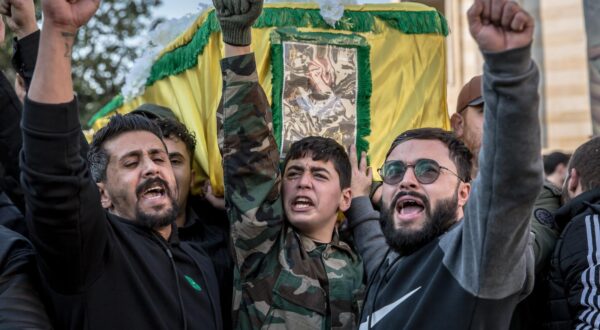 Men shout pro-Hezbollah slogans in front of the coffin of a Hezbollah fighter killed by Israel during a funeral in Souaneh. Many of the dead were buried temporarily or held in healthcare facilities until their families could return home after the ceasefire to hold a funeral. (Photo by Sally Hayden / SOPA Images/Sipa USA) Photo: SOPA Images/SIPA USA