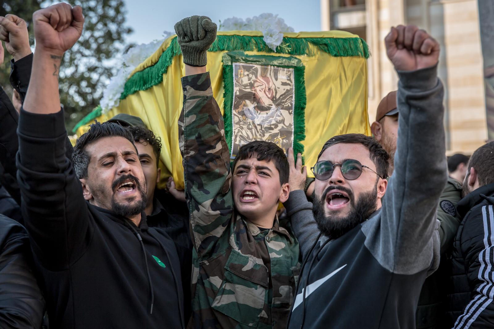 Men shout pro-Hezbollah slogans in front of the coffin of a Hezbollah fighter killed by Israel during a funeral in Souaneh. Many of the dead were buried temporarily or held in healthcare facilities until their families could return home after the ceasefire to hold a funeral. (Photo by Sally Hayden / SOPA Images/Sipa USA) Photo: SOPA Images/SIPA USA