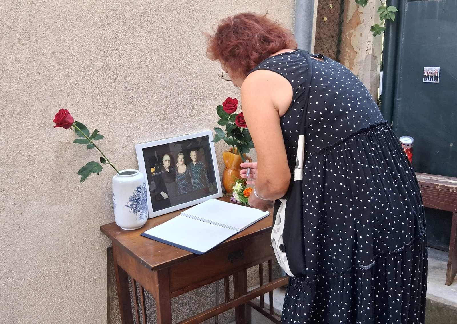 ibenik, 12.8.2025.- Nakon to je u ponedjeljak, dva mjeseca nakon sina Matije Dediæa, preminula i velika Gabi Novak, ibenèani se od jutros oprataju od obitelji Dediæ. Èine to "nazoènoæu, cvijetom i kapljicom ljubavi, onako kako su oni godinama nesebièno darivali nas", poruèili su organizatori. Ispred obiteljske kuæe Dediæevih u ibenskoj Varoi, postavljen je stol s obiteljskom fotografijom Arsena, Gabi i Matije Dediæa gdje ibenèani ostavljaju cvijeæe i svijeæe te upisuju posljednje pozdrave u Knjigu alosti. 
foto HINA/ Snjeana KLARIÆ/ sk